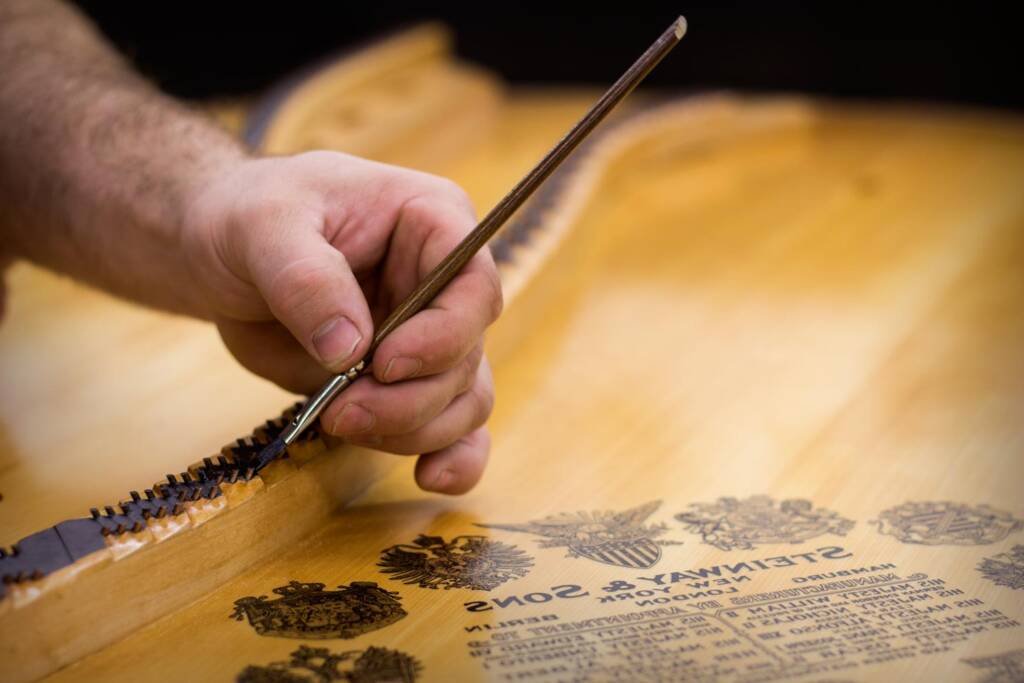 piano technician rebuilding a piano by hand